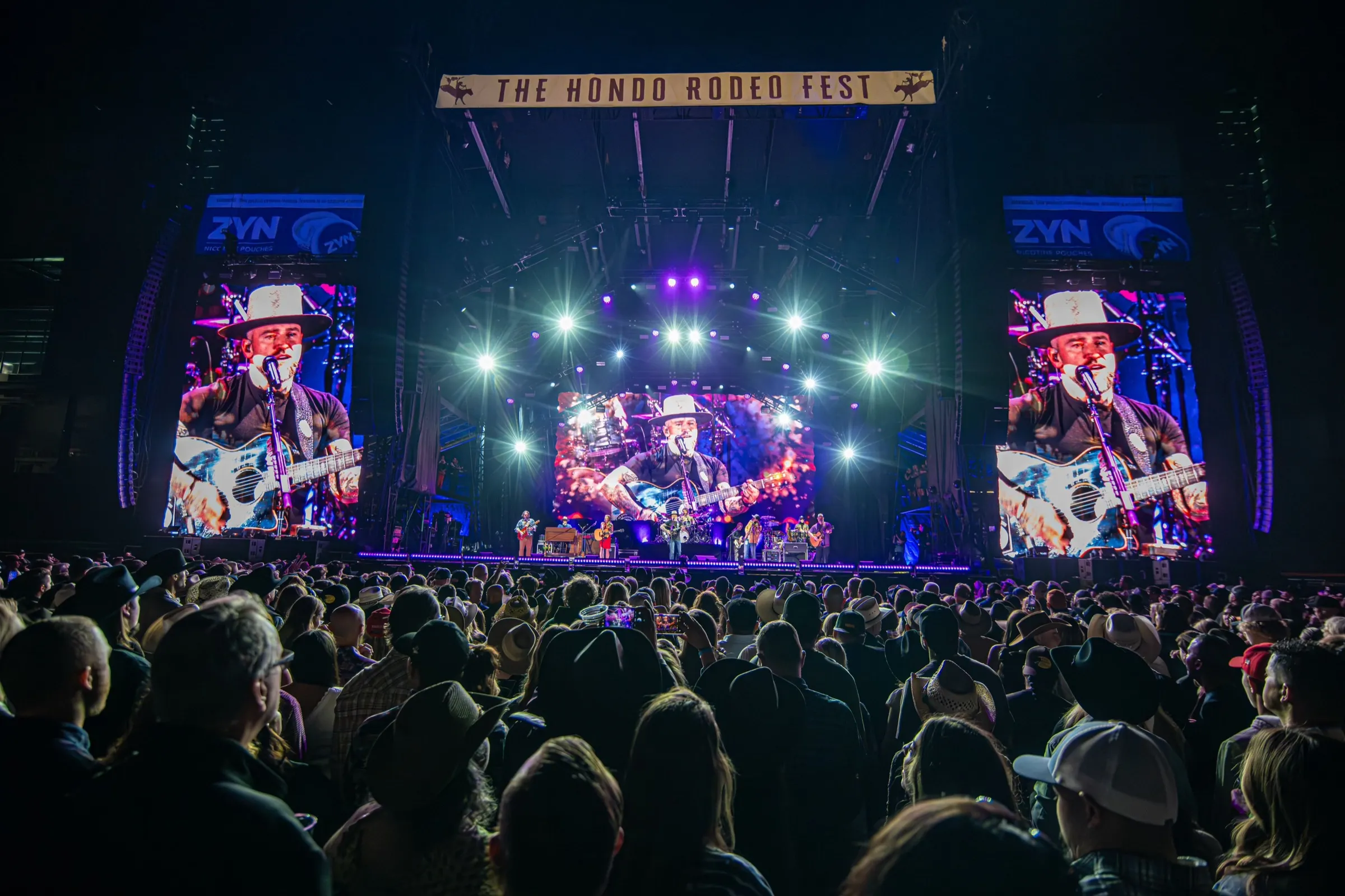 Zac Brown Band on stage under The Hondo Rodeo Fest banner, crowd in the foreground